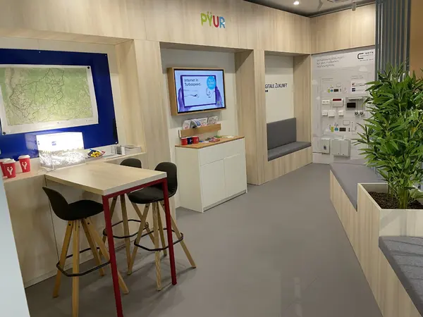 Moderner Showroom mit Infotisch, Stühlen, Wandmonitor und Smart-Home-Technik.